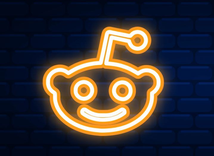 Reddit logo in neon orange against a black background.