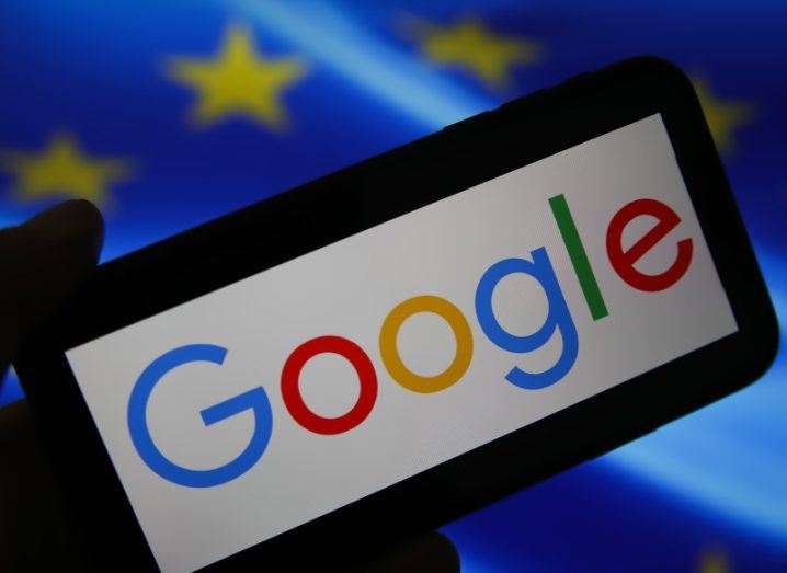 A phone with the Google logo and branding on it lying on the EU flag.