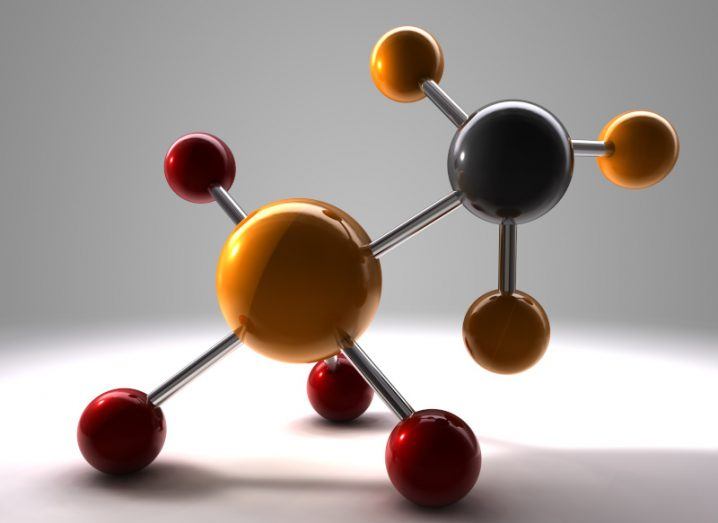 A close-up of a molecule model with orange and red balls.