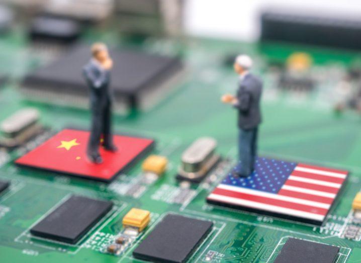 Figure dolls of Joe Biden and Xi Jingping standing on computer chips with the US and China flagss, facing each other. Symbolises the ongoing US chip ban on China.