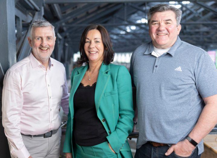 Two men stand on either side of a woman as they pose for a photograph. All three are executives at Whyze Health.