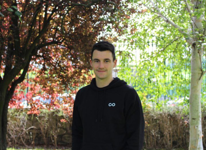 Noloco CEO Darragh Mc Kay wearing a hoodie and standing in the outdoors with trees visible behind him.
