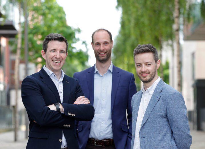 The three co-founders of EdgeTier stand next to each other wearing suits in the outdoors.