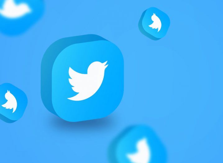 One big Twitter logo in a 3D box and other logos in different angles and some blurred and smaller around it on a blue background.