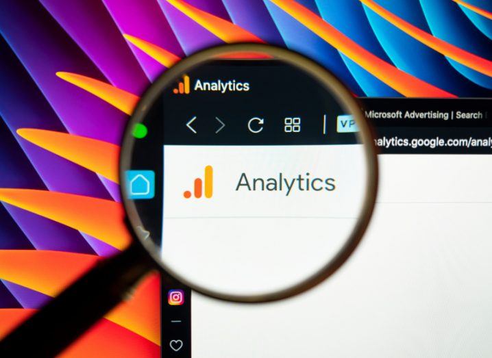 The Google Analytics logo on a screen with a magnifying glass over it.