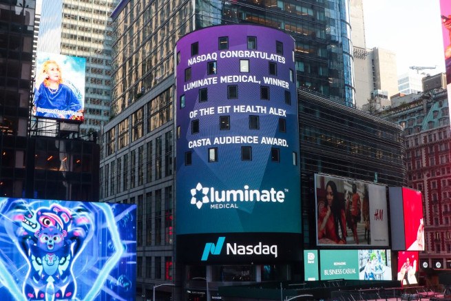 A large LED screen at the Nasdaq Tower in Times Square with the Luminate Medical logo on it and a message of congratulations.