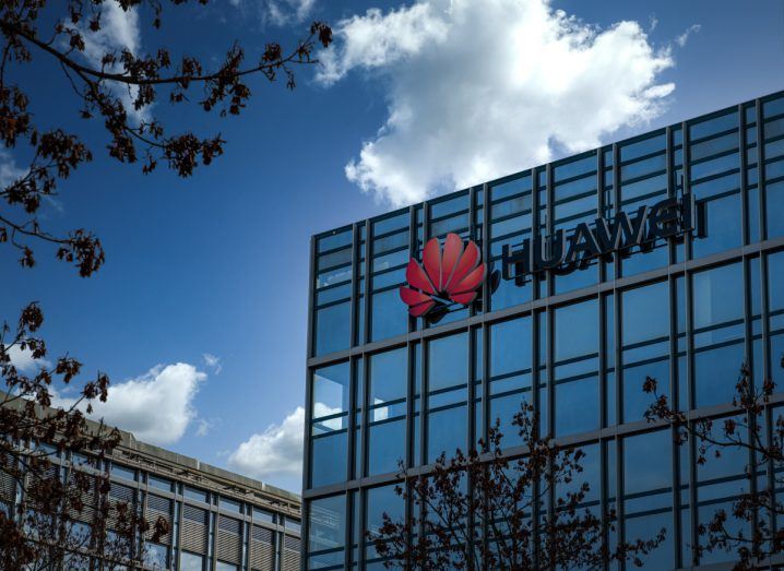 Huawei logo on a building with a blue sky in the backdrop.