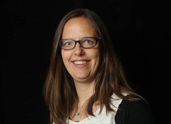 A headshot of Dr Mélanie Bouroche smiling at the camera against a black background.