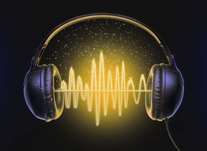 Illustration of black headphones with yellow sound waves between the center of them, on a dark background.