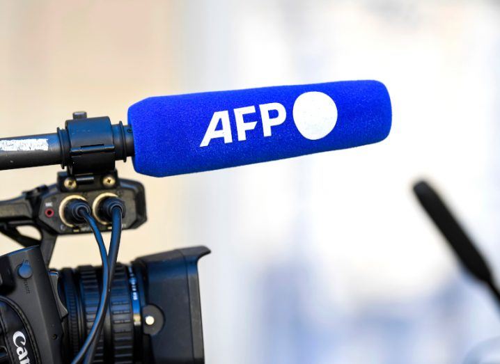 The AFP logo on a microphone, connected to a TV camera.