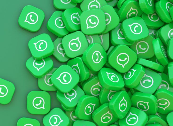 A large pile of green squares with the WhatsApp logo on them, laying on a darker green surface.