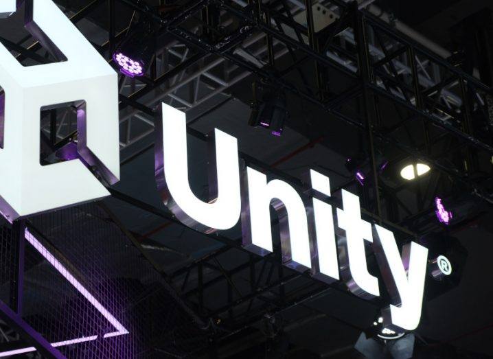 The Unity logo in a large room, with a black roof and bars above it.