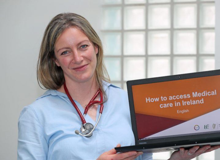 A woman holding a laptop in a room. She is Doctor Catherine Clifford of Translate Ireland.