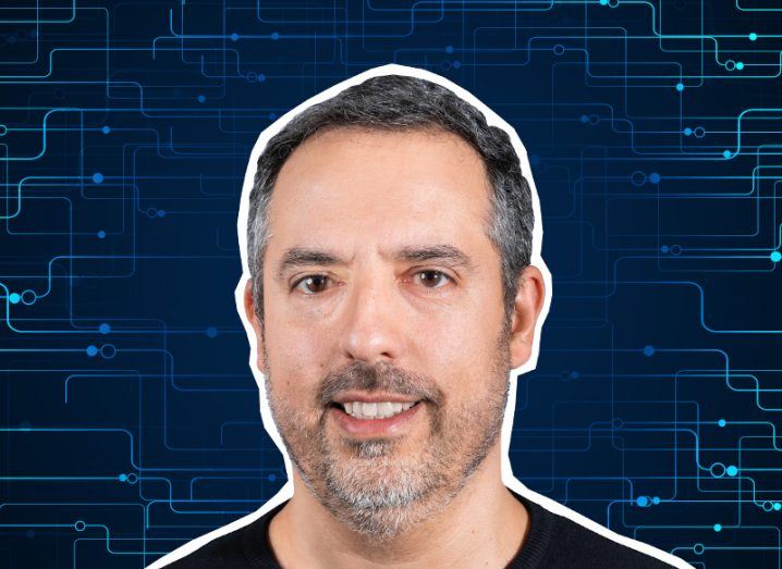 A man smiles at the camera wearing a dark shirt. There is a blue digital background behind him that resembles circuitry. He is Pedro Fortuna, co-founder and CTO of Jscrambler.