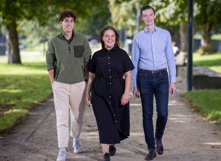 The three founders of Micron Agritech walking down a road through a park.