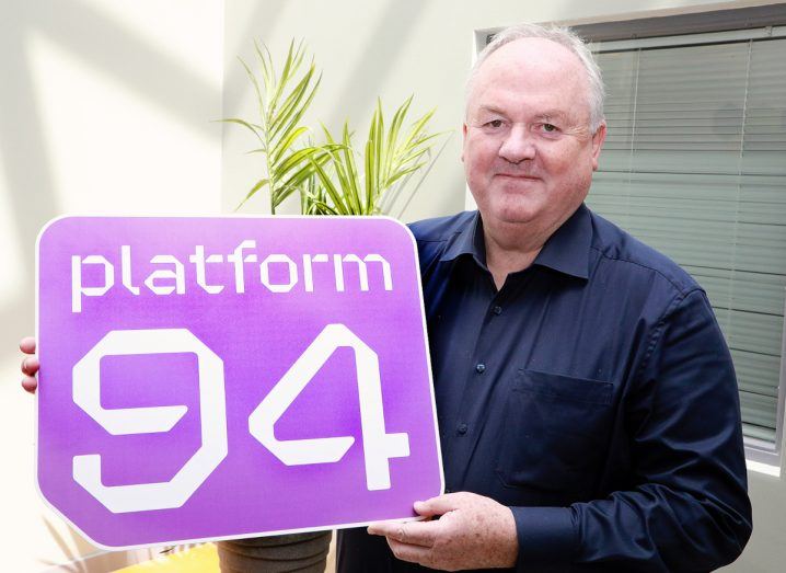 A man holding a poster that has the Platform94 logo on it.