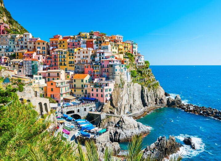 Scenic Italian town on a mountain next to a blue sea.