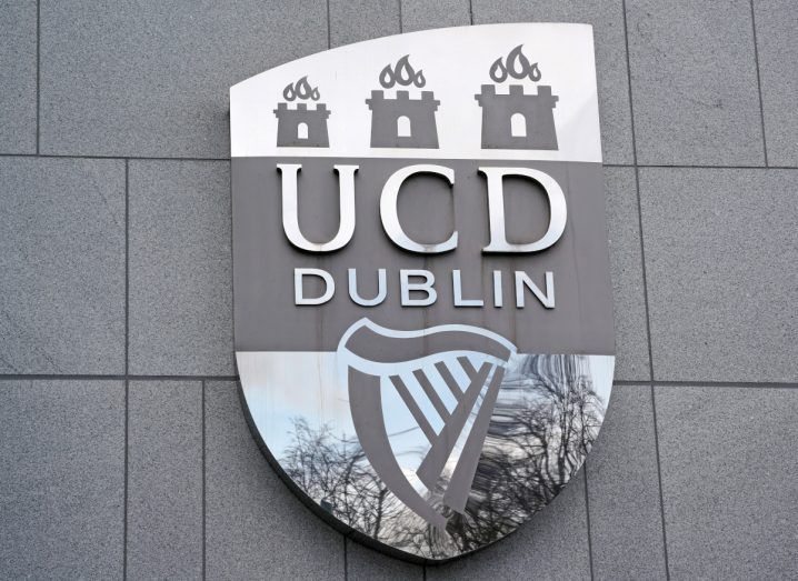Logo of UCD in gray on a building in Dublin.