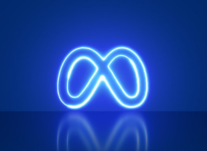The Meta logo lit up in neon blue, in a dark blue background.