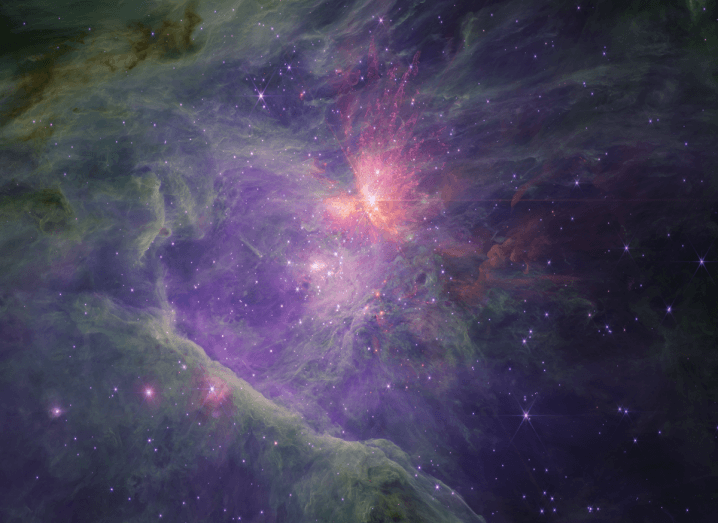 Image of the radiant Orion Nebula with multicoloured gas clouds and clusters of stars. The centre of the image shows a bright cluster of stars.