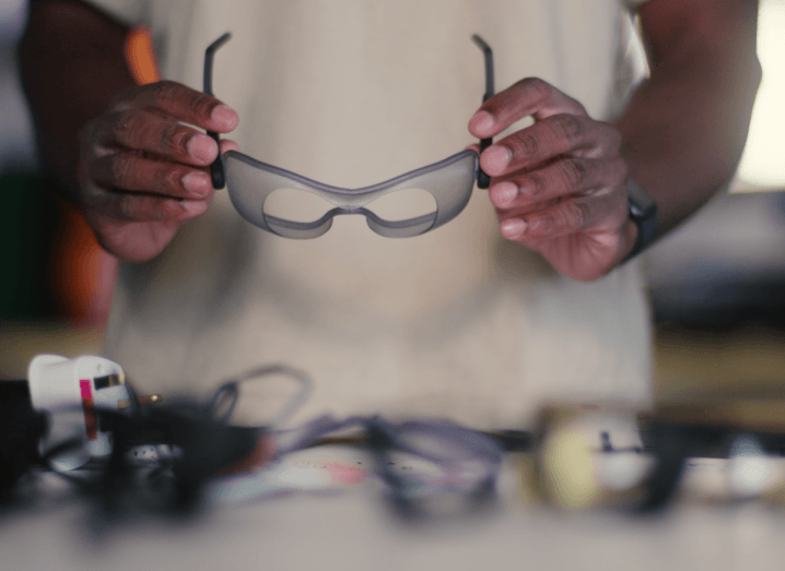 A man holding the Oasis wearable glasses device in his hand. The device has been shortlisted for the James Dyson Award.