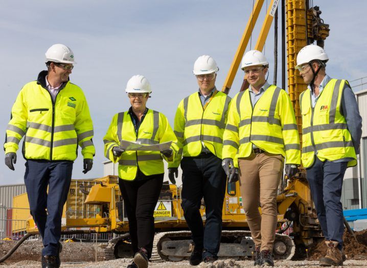 Five people wearing construction outfits walking in what appears to be the Little Island site of PepsiCo in Cork, Ireland.
