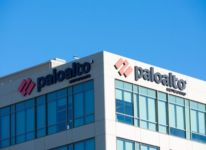 A building with the Palo Alto Networks logo on two sides of it and a clear blue sky above the building.