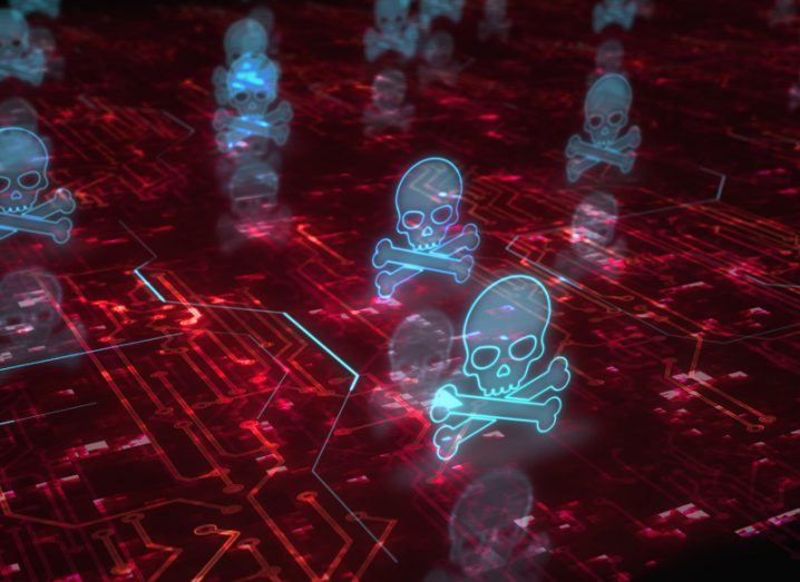 Digital image of multiple skulls with crossed bones underneath, hovering above a red surface. Used to represent the concept of cyberattacks.