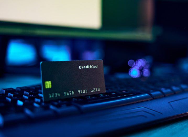 A credit card laying on a keyboard, with a monitor in the background. Used for the concept of data breaches and exposed financial information.