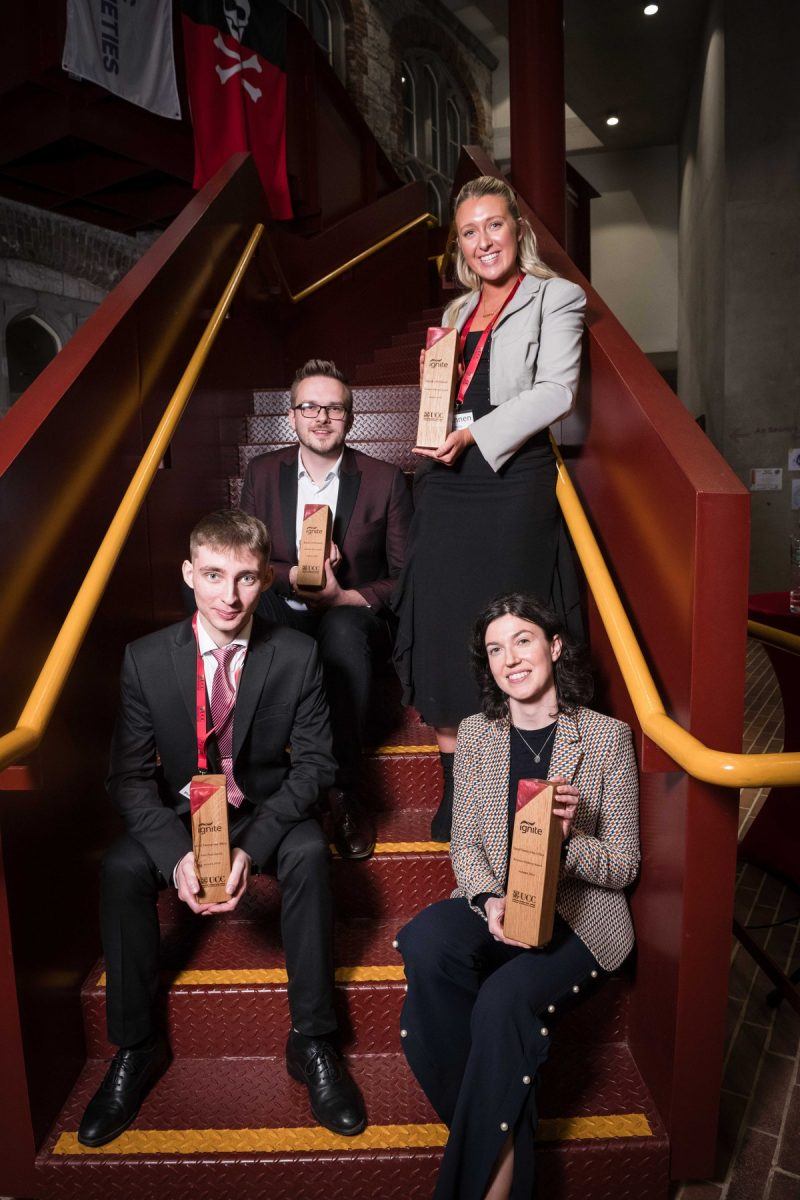 Two men and two women on a staircase, holding Ignite awards.