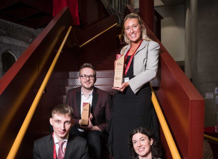 Two men and two women on a staircase, holding Ignite awards.