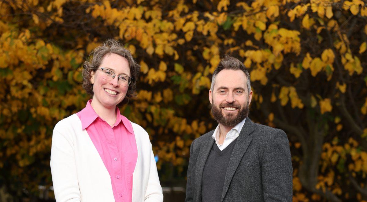 A woman and a man standing together with trees and autumn leaves in the background. They are researchers from University College Dublin.