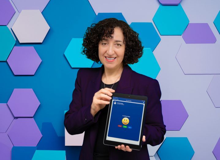 Headshot of Doctor Aviva Cohen holding a tablet in her hand with the SeamlessCare app open.