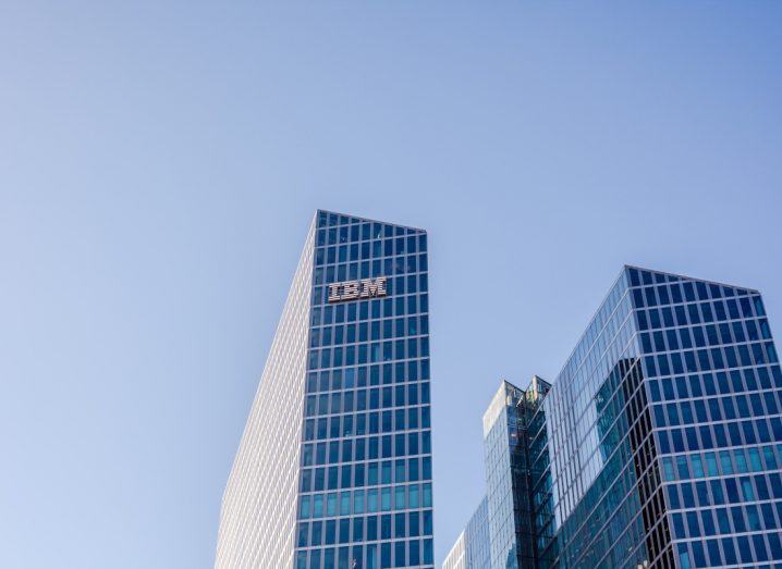 IBM logo on a tall building with a blue sky as the backdrop.