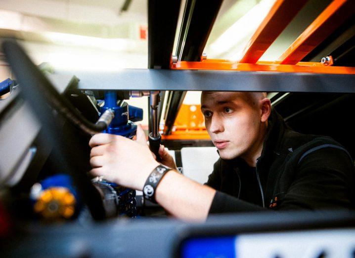 A young man working on a part of the Life Chariot ambulance that won a James Dyson Award.