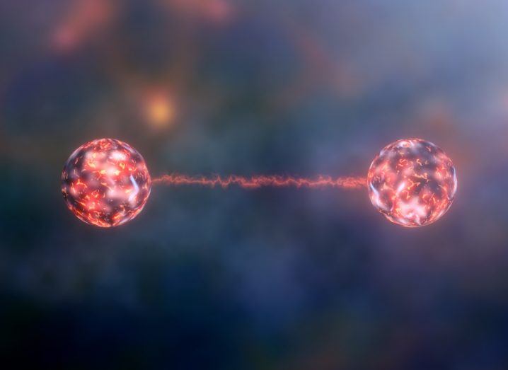 An illustration of quantum entanglement with two pink atoms.