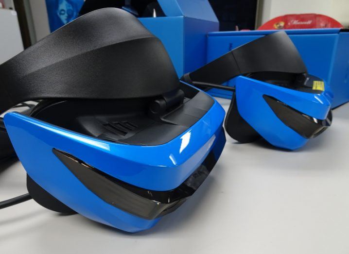 Two Windows Mixed Reality headsets on a grey surface.