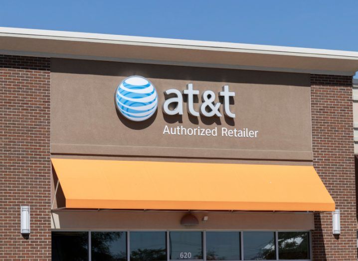 The AT&T logo on the front of a brown building, with a blue sky above.