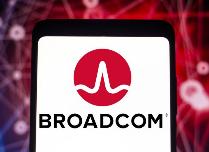 The Broadcom logo on a smartphone screen, with a red background behind the phone.