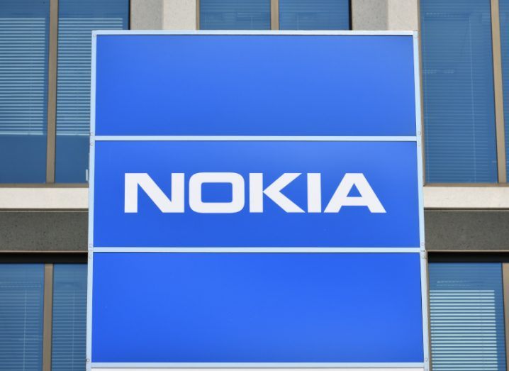 The Nokia logo on a blue box in front of a building.