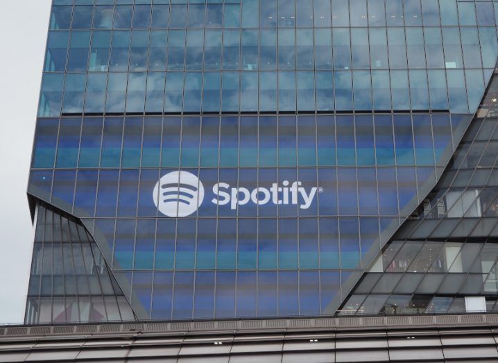 The Spotify logo on the front of a large windowed building.
