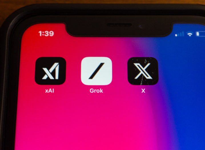 A mobile phone screen showing app logos of xAI, Grok and X.
