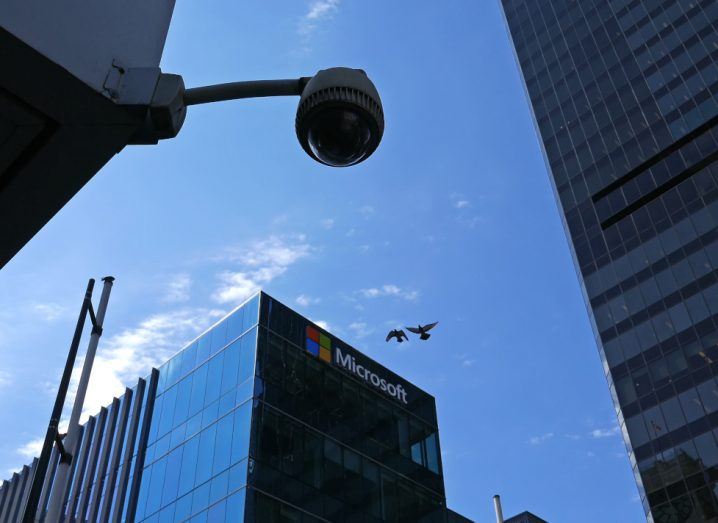 Microsoft logo on a building with a CCTV camera in the foreground.