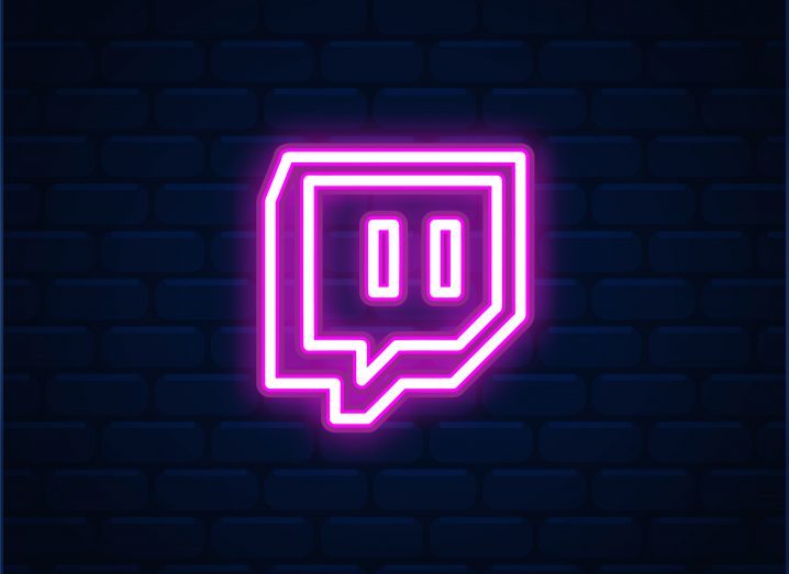 Twitch logo in neon pink over a dark background with a brick-like design.