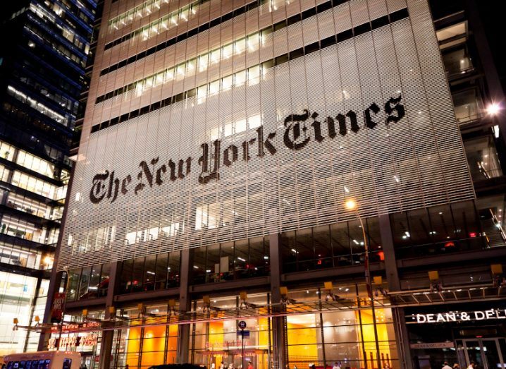 A building at night with The New York Times logo on the front of it.