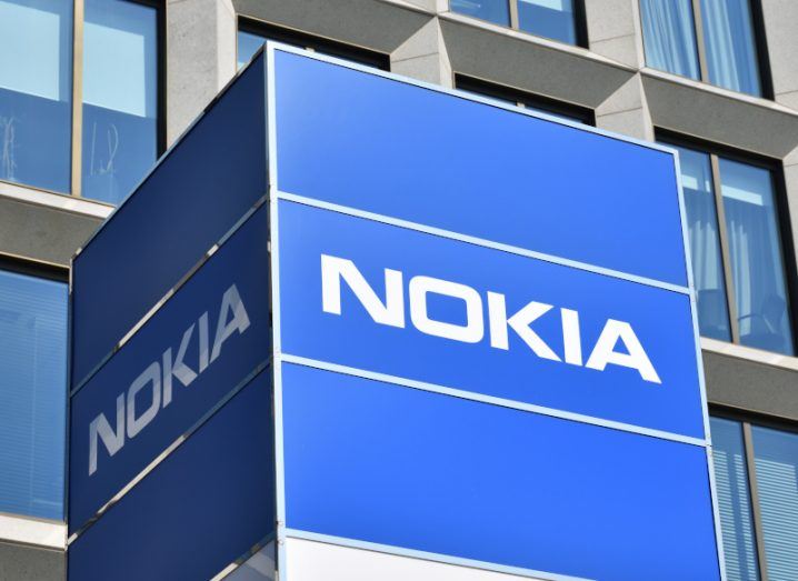 The Nokia logo on a blue cube in front of a building.
