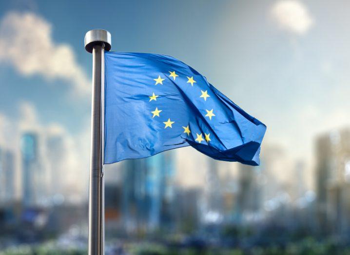 The EU flag with a city in the background.