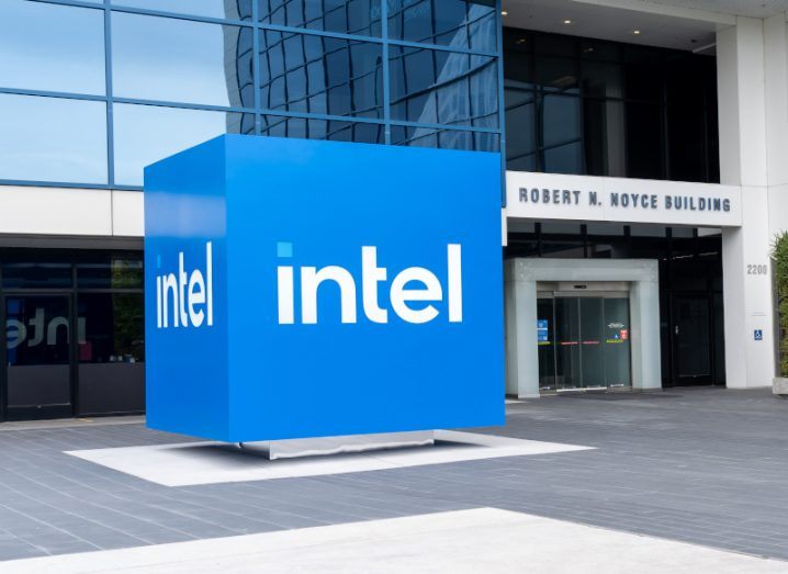 A large Intel logo sign outside a building on a sunny day.