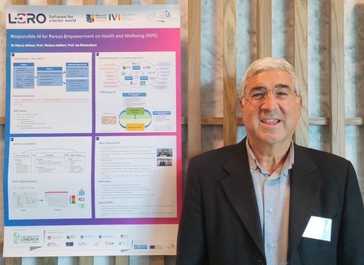 Dr Marco Alfano stands next to a poster presentation for research with the Lero logo on it.