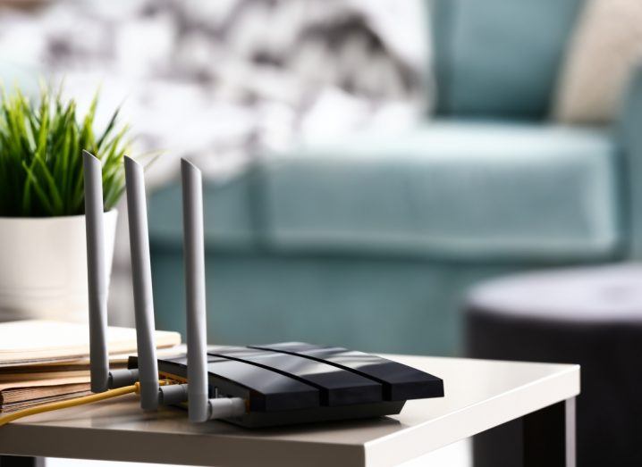 A Wi-Fi router on a table in what appears to be a living room.